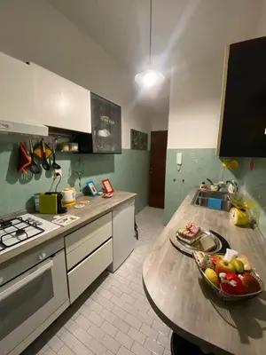 a kitchen with a table with a bowl of fruit on it at Garbatella, lovely mini apartment in Rome