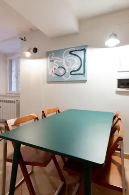 a green table in a room with chairs at Peaceful hidden gem near Metro A and Colosseum in Rome