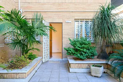 a courtyard with palm trees in front of a building at Giardinetto 14 in Rome