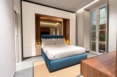 a bedroom with a bed and a blue couch at Domus Suites Colosseum in Rome