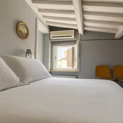 a bedroom with a white bed and a window at The Artist's nest - Trastevere- Rome in Rome