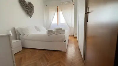 a white bedroom with a bed and a window at La Camilla in Rome