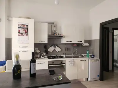 a kitchen with white cabinets and a bottle of wine at P7 Casa Roma in Rome