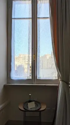 a table in front of a window with a bottle of wine at Giuliana32 in Rome