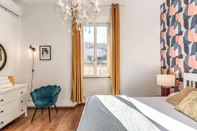 a bedroom with a bed and a chair and a window at AwesHomeItaly - Spagna Glamour Life Penthouse in Rome