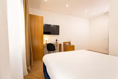 a hotel room with a bed and a chair at Affresco LR Collection in Rome