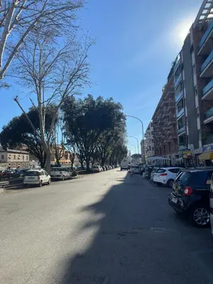 an empty street with cars parked on the side of the road at Ostiense - San Paolo Garbatella - Università Roma 3 in Rome