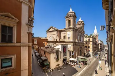 an old building with a clock tower on a street at Piazza di Spagna Comfort Rooms in Rome