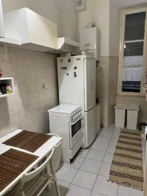 a kitchen with a refrigerator and a table in it at SweetHome Lisa in Rome