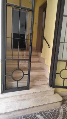 a set of stairs with a metal railing next to a door at Appartamento esclusivo Casalino Vatican Suite in Rome