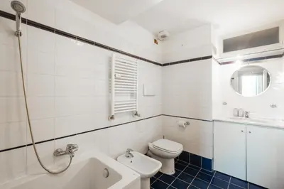 a white bathroom with a toilet and a sink at Esquilino Lightsome Apartment in Rome