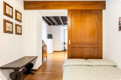 a room with a bed and a wooden door at Piazza Farnese house in Rome