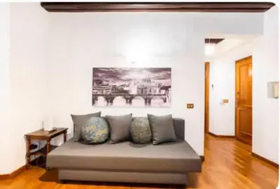 a couch in a living room with a painting on the wall at Piazza Farnese house in Rome