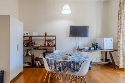 a dining room with a table and white chairs at TURATI GUEST HOUSe in Rome