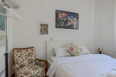 a bedroom with a bed and a chair next to it at TURATI GUEST HOUSe in Rome