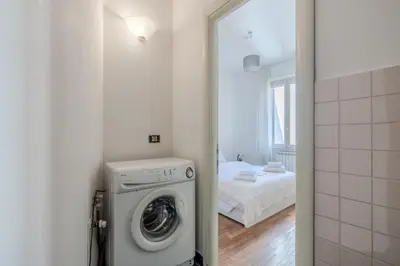 a bathroom with a washing machine and a bedroom at TURATI GUEST HOUSe in Rome