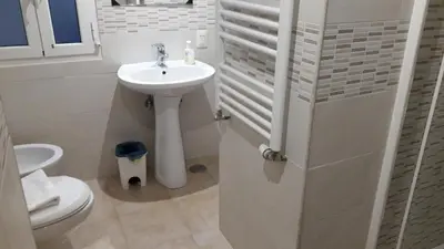 a white bathroom with a sink and a toilet at Casa Vacanze Nonno Giulio in Rome