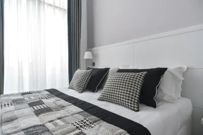 a bed with black and white pillows on it at Lata Luxury Rooms in Rome