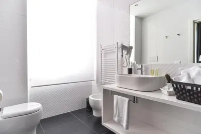 a bathroom with a sink and a toilet and a mirror at Lata Luxury Rooms in Rome