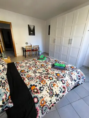 a bedroom with a bed with a flowered blanket at Basilica santa Maria ausiliatrice in Rome