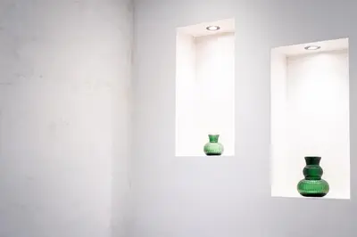 two green vases on shelves in a white room at Sanpietrino Apartment in Rome