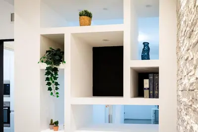 a white book shelf with two plants on it at Sanpietrino Apartment in Rome
