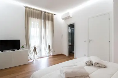 a white bedroom with a bed and a television at Da Eleonora - Centro di Roma in Rome