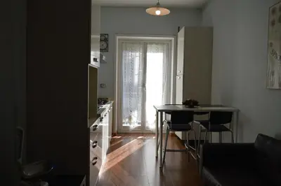 a living room with a table and a kitchen with a window at Appartamento Elena's House in Rome