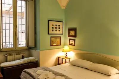 a green bedroom with a bed and a lamp at Domus Vaticanae in Rome