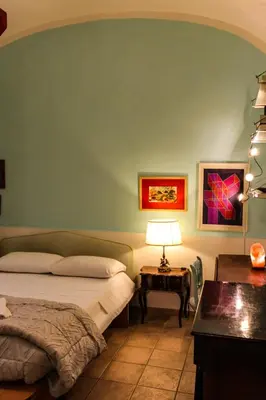 a bedroom with a bed and a table with a lamp at Domus Vaticanae in Rome