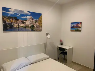 a bedroom with a bed and a desk and a painting at unica-vatican museum in Rome