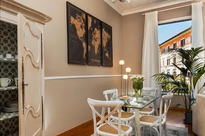 a dining room with a table and chairs and a window at Maisondesfleurs in Rome