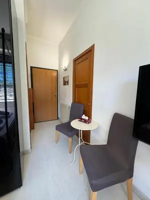a room with two chairs and a table and a door at Mila House in Rome