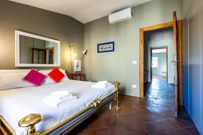 a bedroom with a bed with red pillows and a mirror at Attico Spazioso ed Elegante a Santa Maria Maggiore in Rome