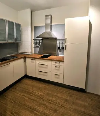 a kitchen with white cabinets and a white refrigerator at Residenza Roma 19 in Rome