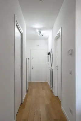 an empty hallway with white walls and wooden floors at Green park apartment in Rome