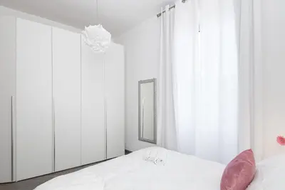a bedroom with white walls and a bed with a mirror at asyouRhOME - Nico - San Pietro Vaticano in Rome