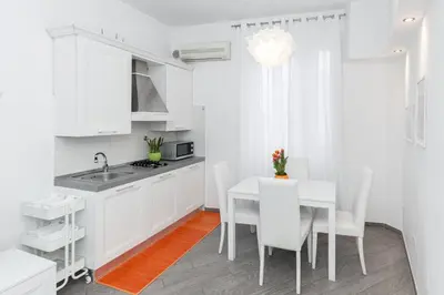 a kitchen with white cabinets and a table and chairs at asyouRhOME - Nico - San Pietro Vaticano in Rome