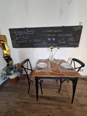 a table with two chairs and a chalkboard on the wall at La casa Di Tommi a Ponte Milvio in Rome