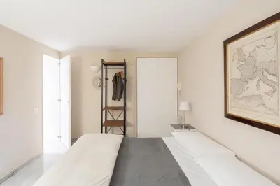 a white room with a bed and a map on the wall at Maison Barchetta in Via Giulia in Rome