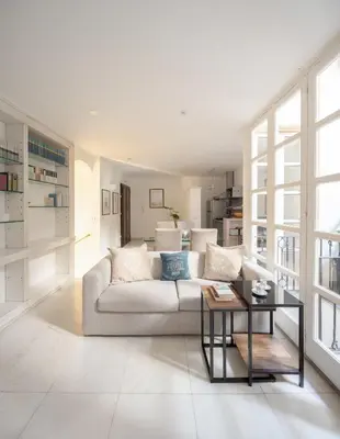 a white living room with a couch and a table at Maison Barchetta in Via Giulia in Rome