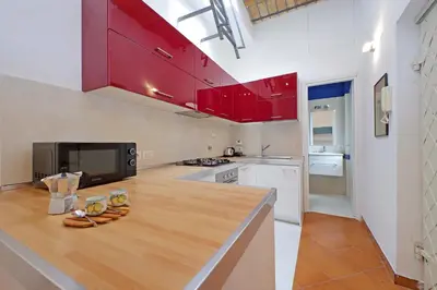 a kitchen with red cabinets and a counter top at Cinque in Rome