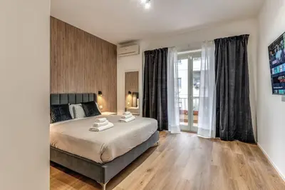 a bedroom with a large bed and a large window at Vatican Private Apartment in Rome