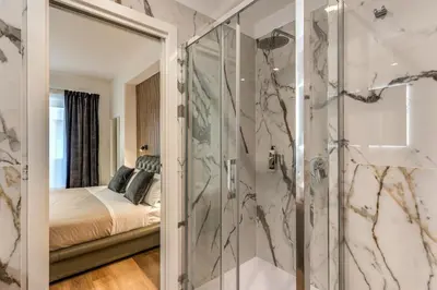 a bathroom with a shower and a bed at Vatican Private Apartment in Rome