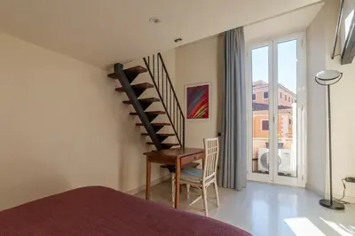 a bedroom with a staircase and a chair and a window at Casa Emma - Charme Holidays in Rome