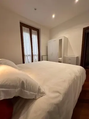 a bedroom with a large white bed and two windows at Casa Turchina in Rome
