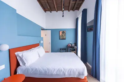 a bedroom with a white bed and blue walls at Interno 12 in Rome