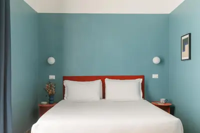 a bedroom with a bed with a blue wall at Interno 12 in Rome