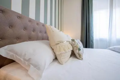 a bed with two pillows on top of it at Morgana - Charming Apartment Close to Vatican in Rome