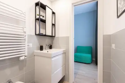 a bathroom with a sink and a green chair at Kimera42 Casa Vacanze in Rome